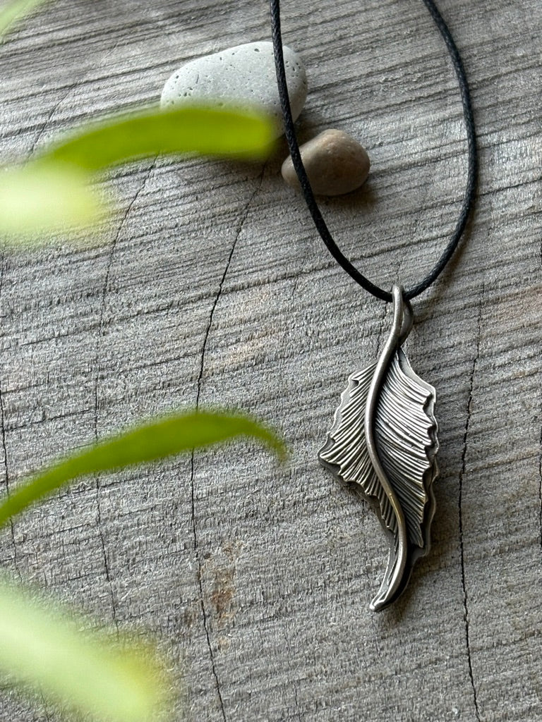 Hand-engraved sterling silver heron feather on balck cord.