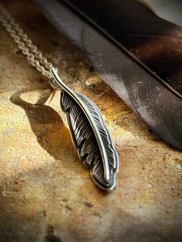 Hand -engraved raven feather on a starling silver chain.